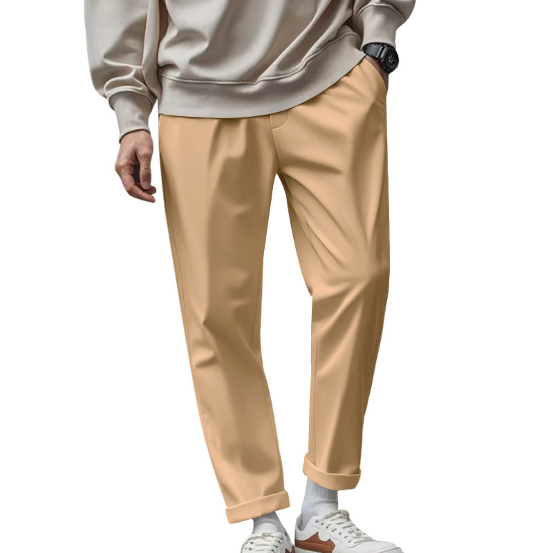 Person wearing beige pants and a light gray sweatshirt on a white background