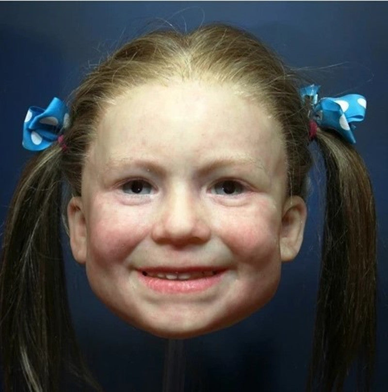 Close-up of a young girl with pigtails and blue hair bows against a dark background