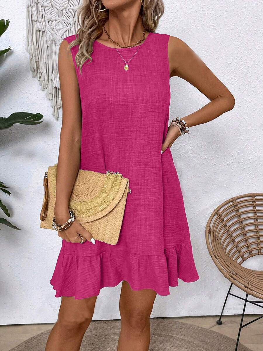 Woman wearing a pink dress holding a straw bag in a casual setting.