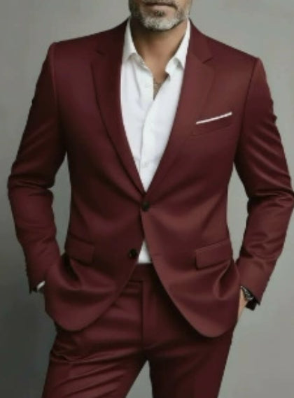 Man wearing a burgundy suit with a white shirt against a gray background