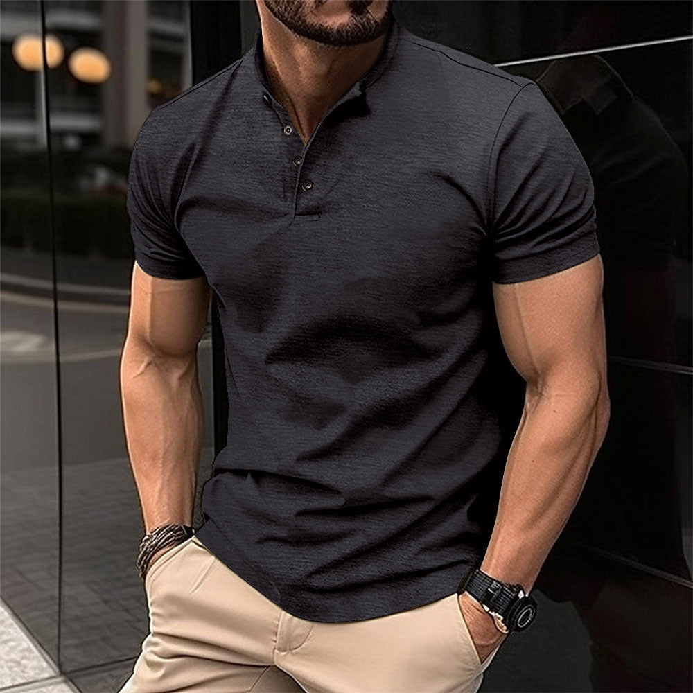 Man wearing a dark gray polo shirt and beige pants in an urban setting