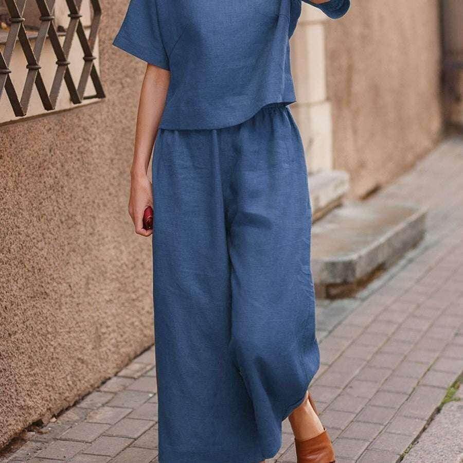 Woman wearing blue wide-leg pants and short-sleeve top from ZA-Zola on city sidewalk