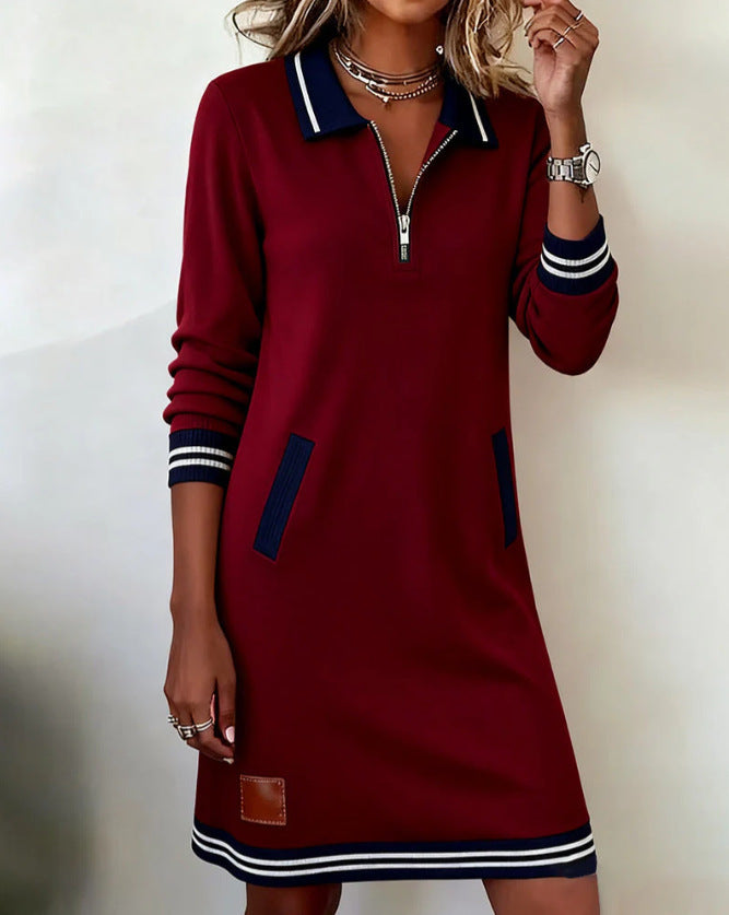 Red dress with blue and white accents worn by a model on a plain background