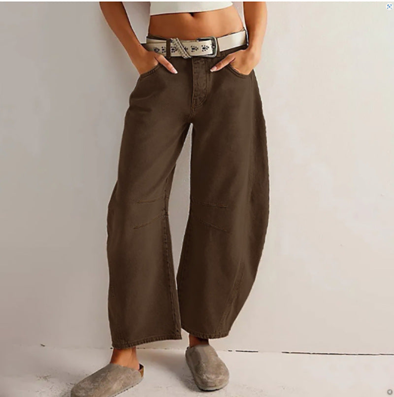 Person wearing brown wide-leg pants with a plain background