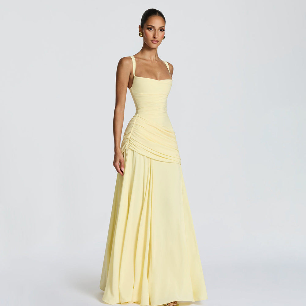 Woman wearing a light yellow evening gown on a plain background