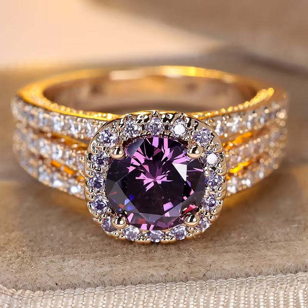 Gold ring with a purple gemstone on a textured surface