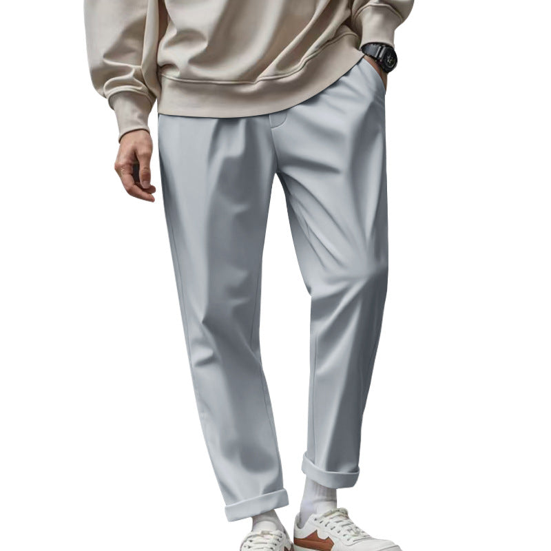 Person wearing light gray pants and a beige sweater on a white background