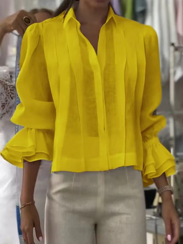 Yellow blouse with ruffled sleeves worn by a person, blurred background