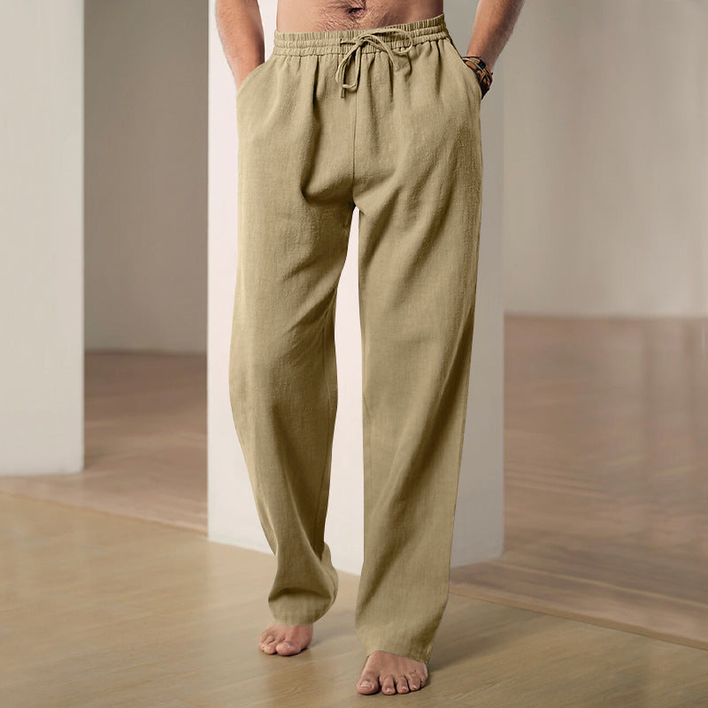 Person wearing beige drawstring pants standing against a neutral background