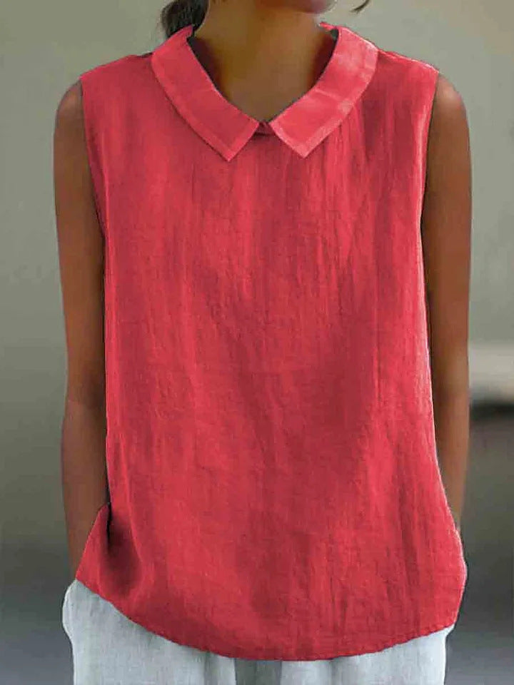 Red sleeveless top with a collar worn by a person against a neutral background