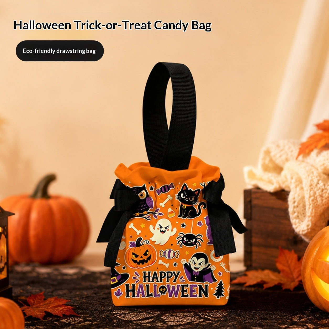 An orange Halloween-themed drawstring candy bag with black ribbon handles and a 'HAPPY HALLOWEEN' print, styled on a table with pumpkins and autumn leaves.