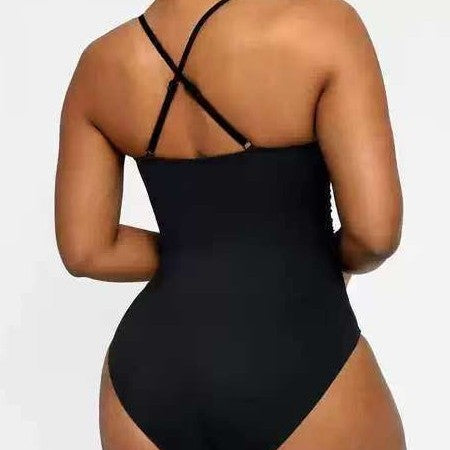 Black swimsuit with criss-cross straps on a plain background