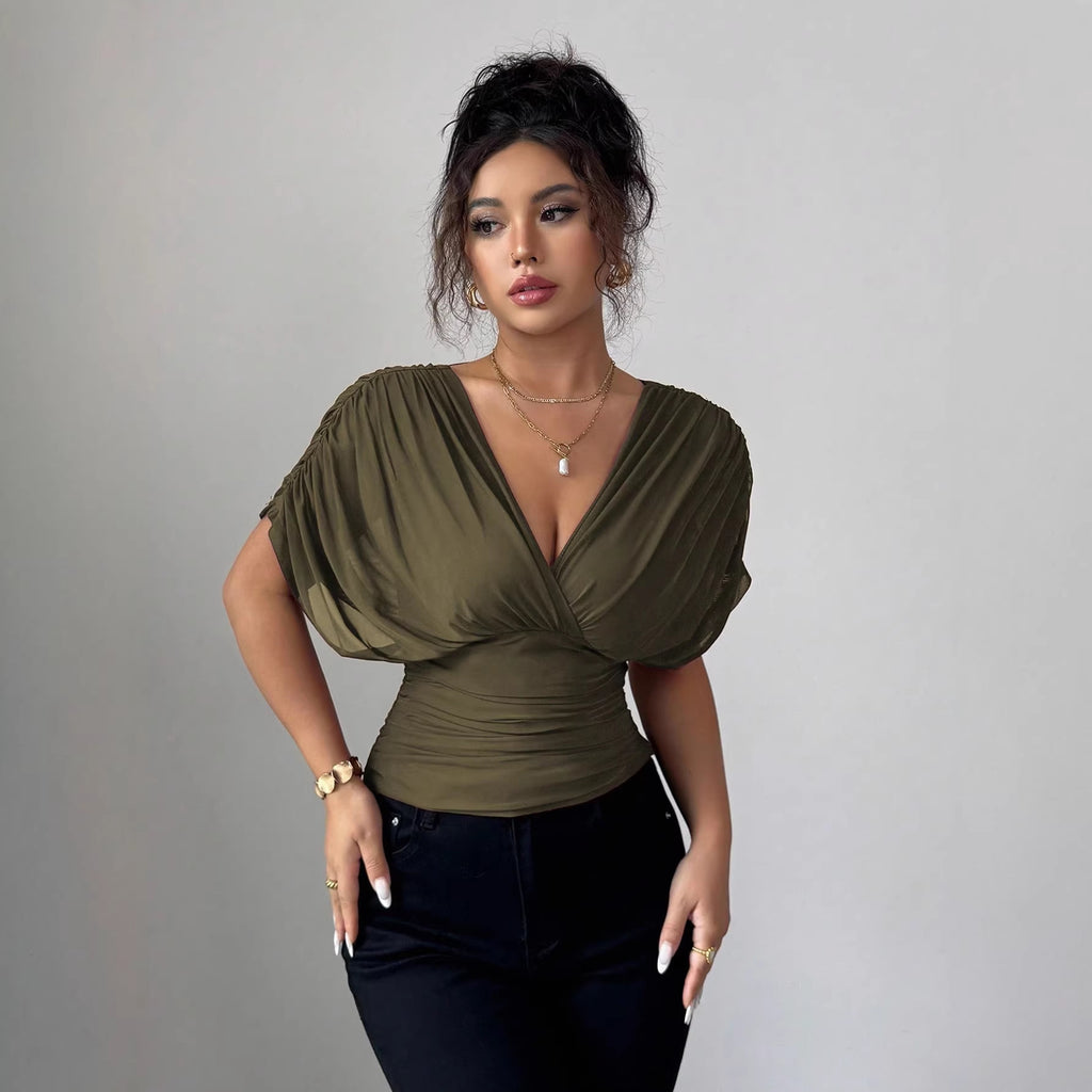 Woman wearing a green top with a gray background