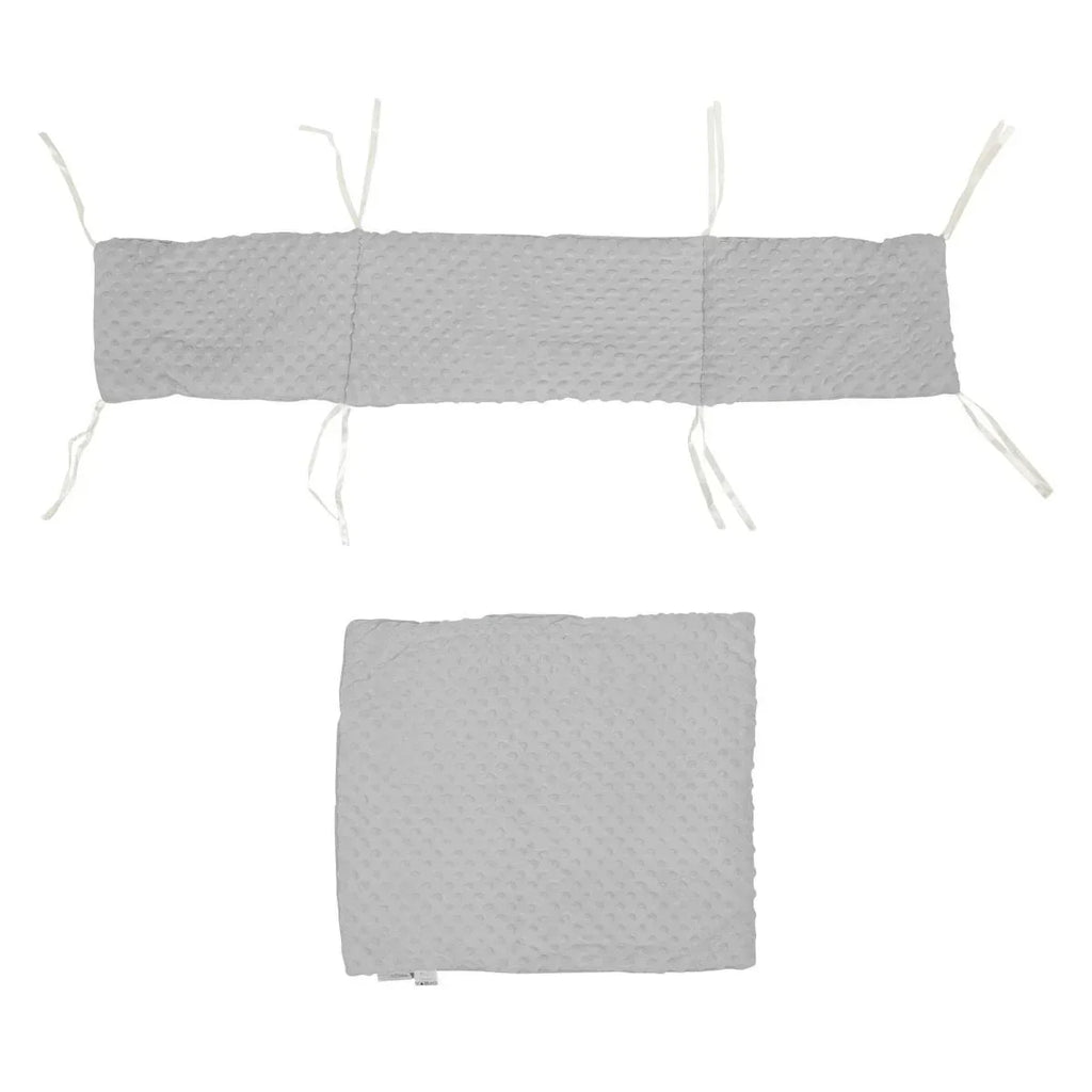 Light grey dimple-textured crib quilt and bumper set with tie fastenings, laid flat.