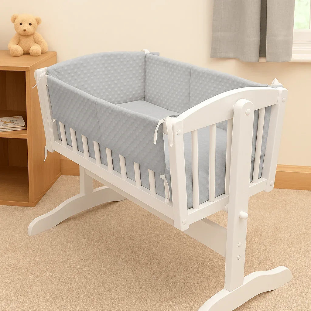 Light grey dimple quilt and bumper bedding set on white wooden cradle in nursery