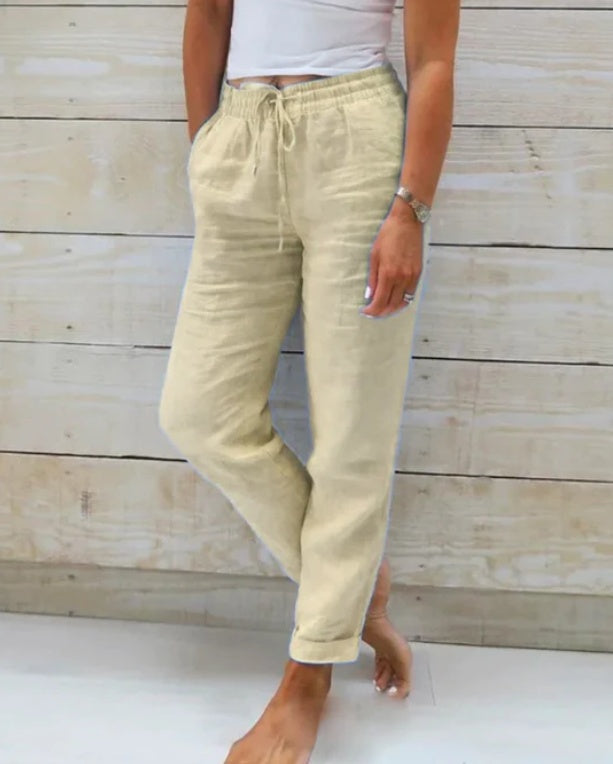 Person wearing beige pants with a white background