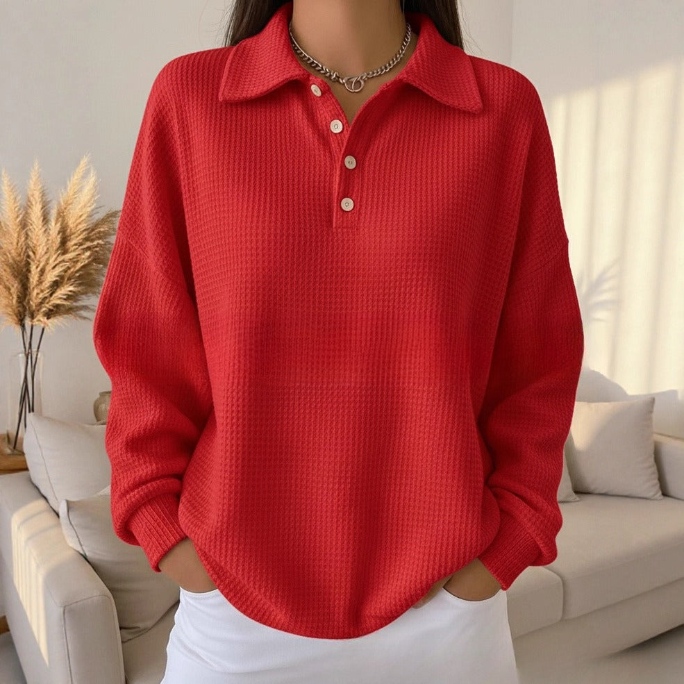 Person wearing a red textured sweater in a living room setting