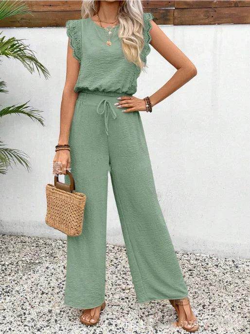 Woman in sage green jumpsuit with lace sleeves, holding woven handbag, ZA-Zola fashion