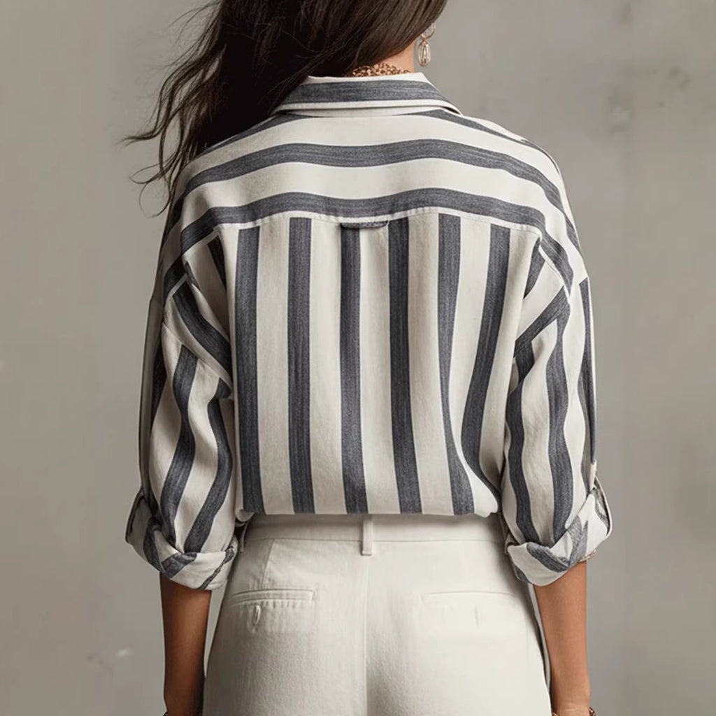 Person wearing a black and white striped shirt against a plain background