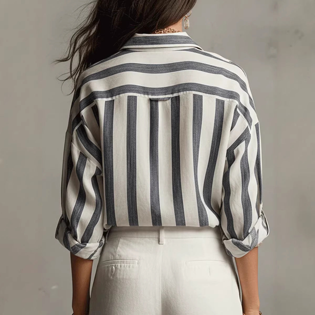 Person wearing a black and white striped shirt against a plain background