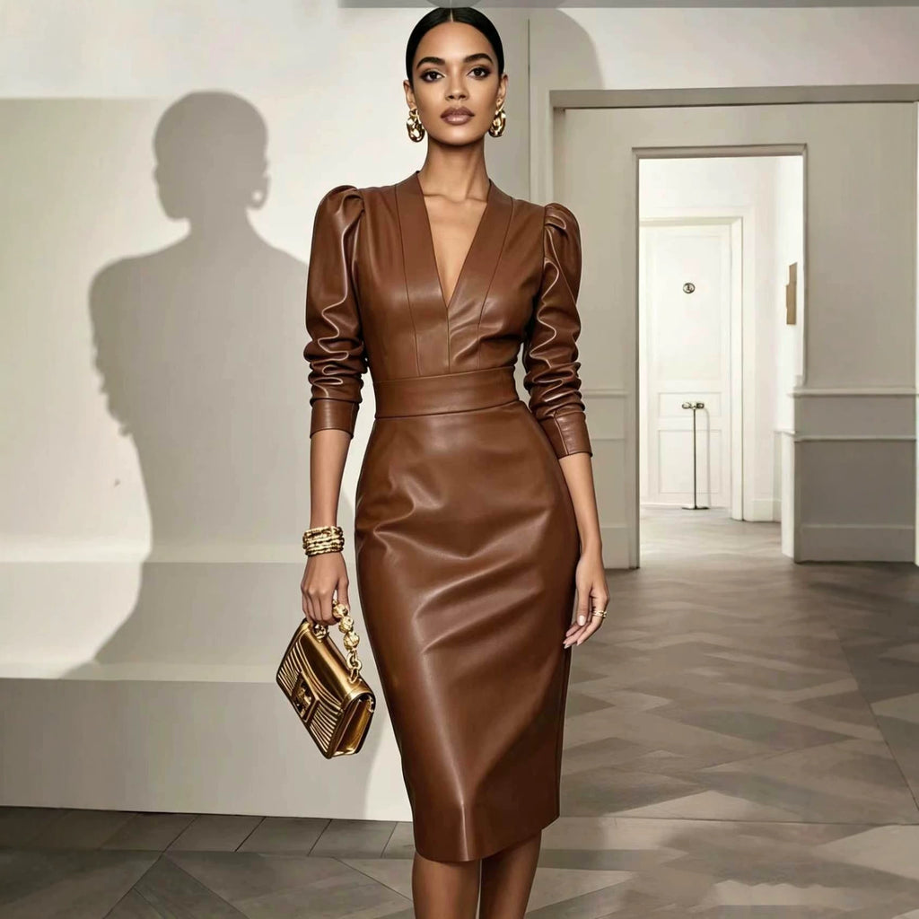 A woman models a brown faux-leather midi dress with puffed 3/4 sleeves, a deep V-neckline, and a fitted waist. She is holding a small gold handbag in a modern hallway with a visible shadow on the wall.