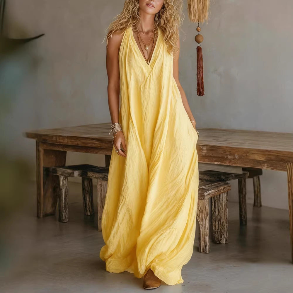 Woman in a yellow dress standing in a room with wooden furniture.