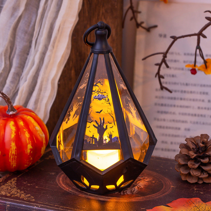 Decorative lantern with Halloween design on a table with pumpkins and a pine cone.