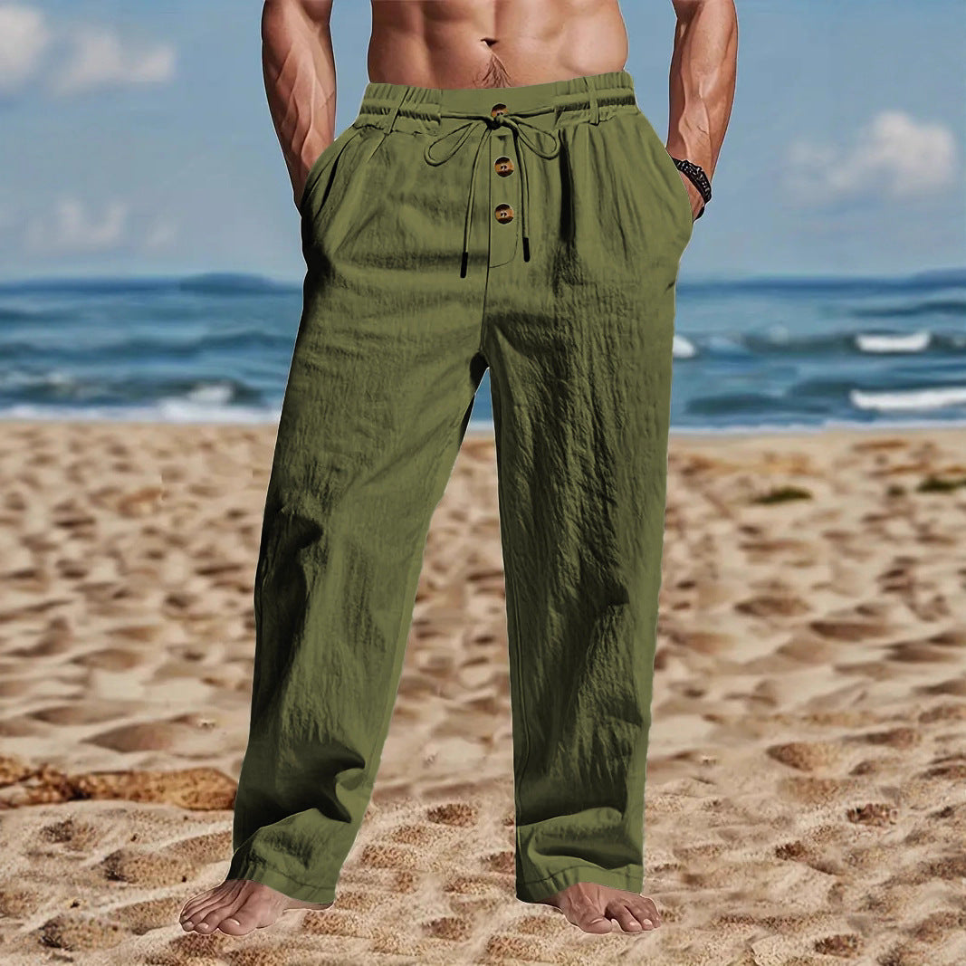 Person wearing green pants on a beach with ocean in the background