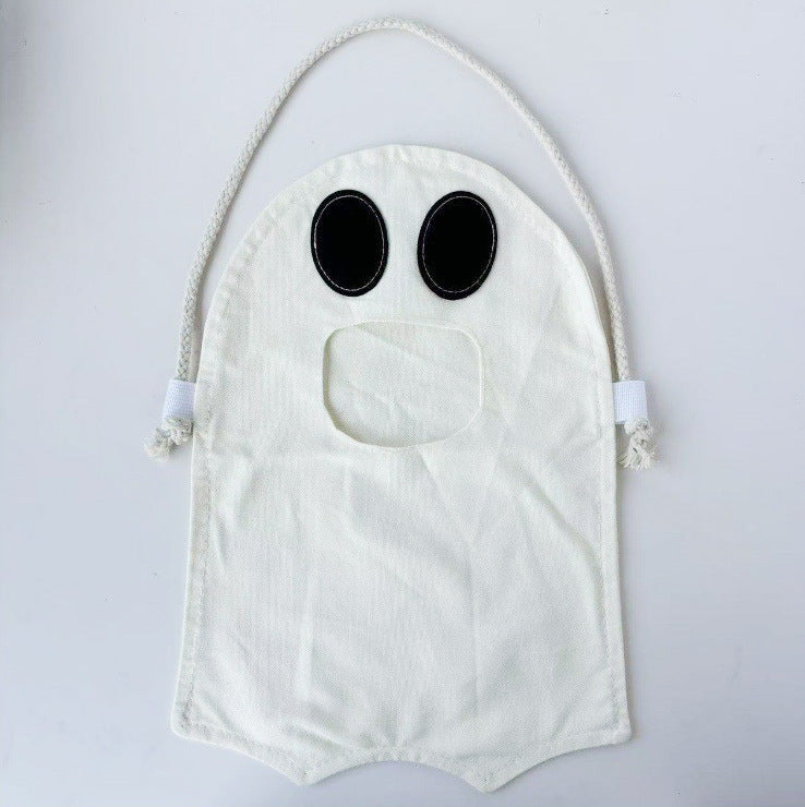 An off-white fabric ghost-shaped bag with black oval eyes and a rope handle, shown against a plain light gray background.