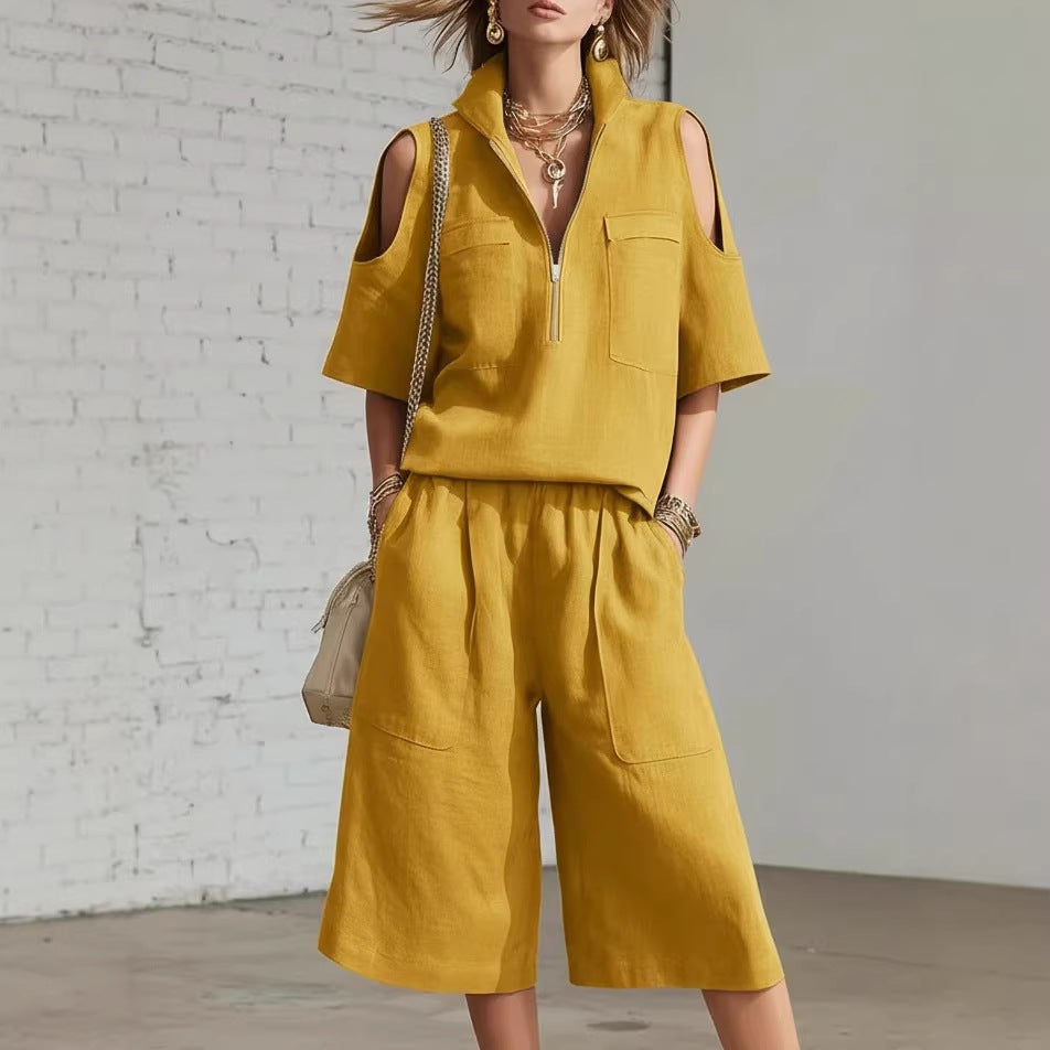 Woman wearing a mustard yellow outfit with a white brick wall background