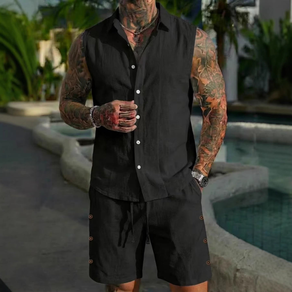 Man wearing a black sleeveless shirt and shorts set with tattoos, standing by a pool.