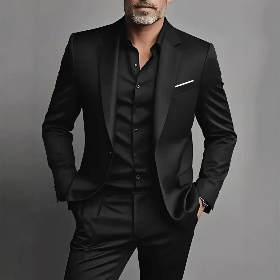 Man wearing a black suit against a gray background