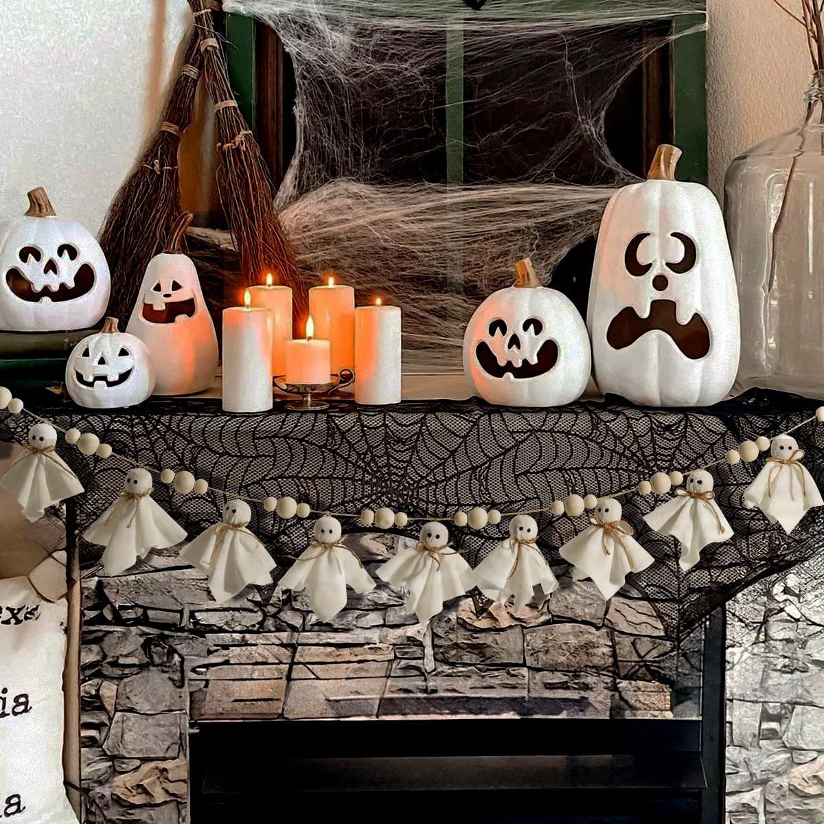 Halloween-themed fireplace with pumpkins, candles, and ghost decorations.