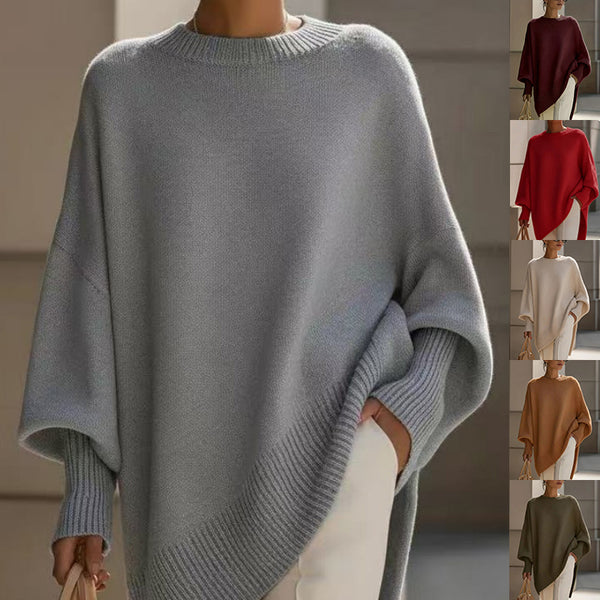 A woman wears an oversized light gray knit sweater with wide batwing sleeves and ribbed cuffs and hem. A vertical strip on the right shows the same sweater in additional colors: burgundy, red, cream, tan, and olive green.