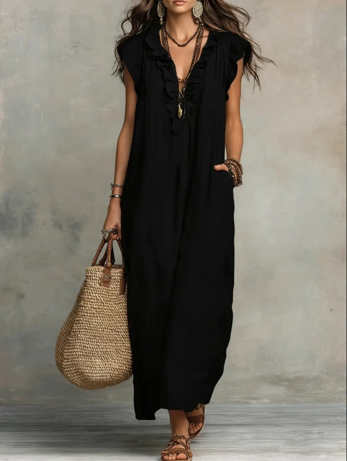 Woman wearing a black sleeveless dress holding a woven bag against a neutral background