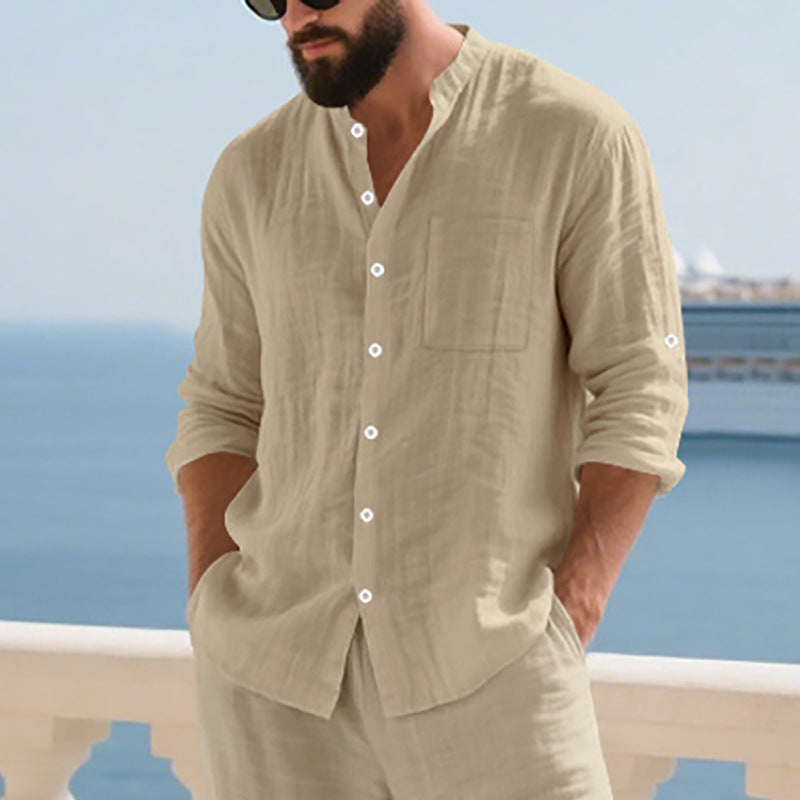 Man wearing a beige shirt and pants with a blurred ocean background