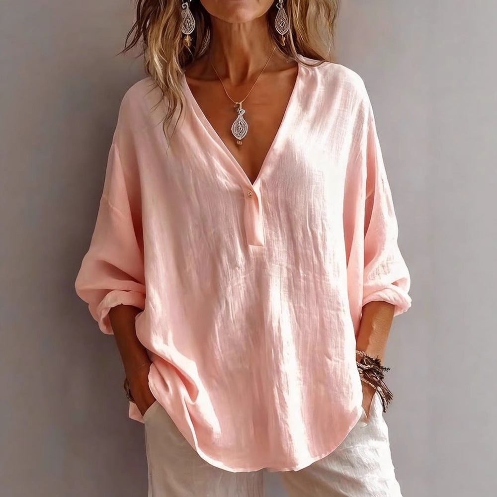 Person wearing a light pink blouse with a plain background