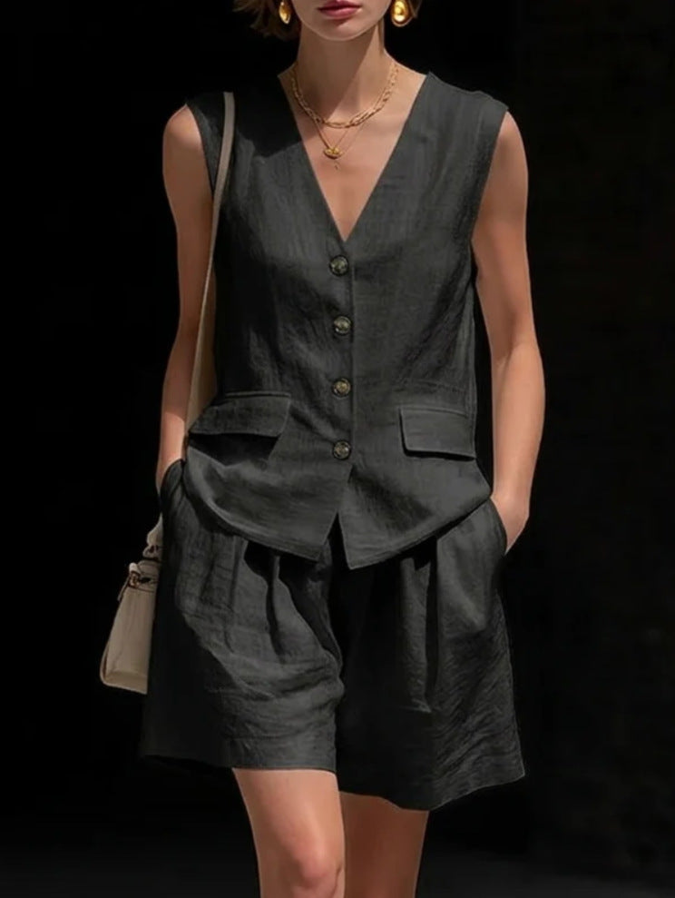 Woman wearing a dark gray sleeveless top and shorts set against a black background