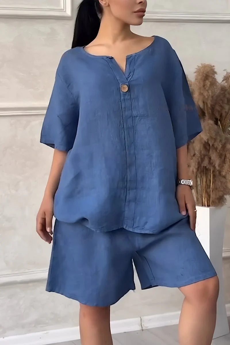 Woman wearing a blue outfit with a buttoned top and shorts in an indoor setting.