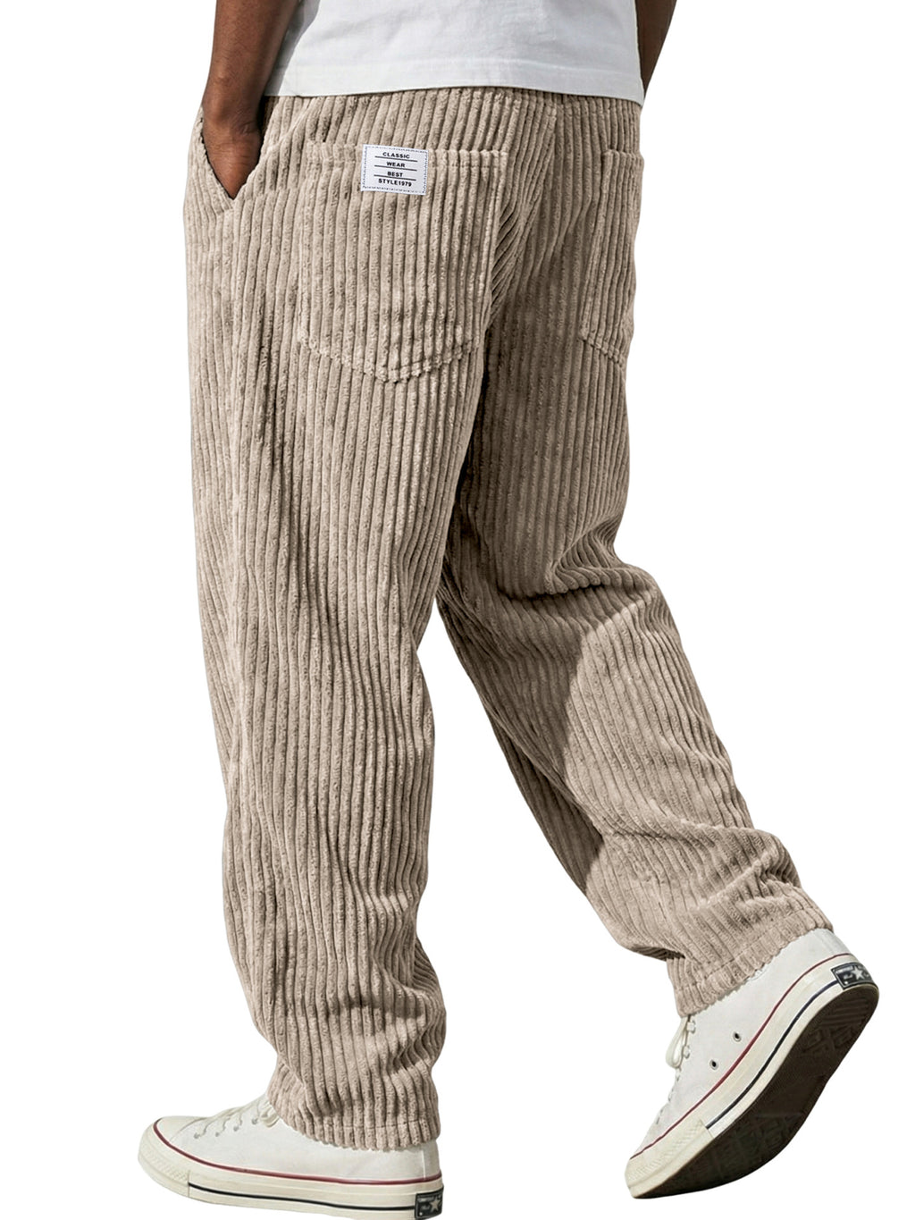 Beige corduroy pants worn by a person on a white background