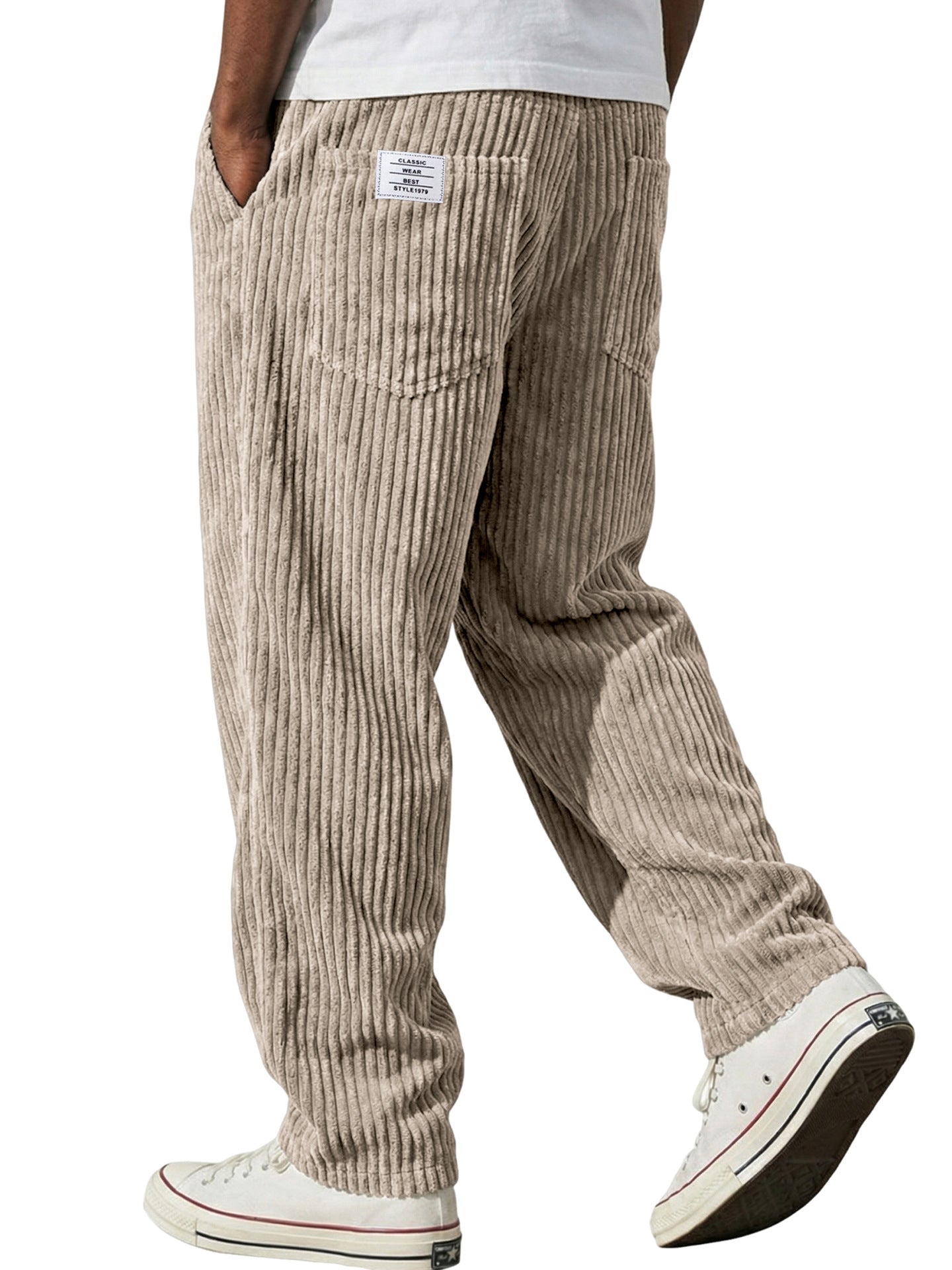 Beige corduroy pants worn by a person on a white background