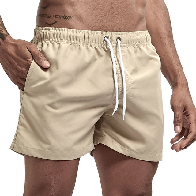 Beige shorts with a white drawstring on a person against a white background