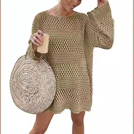 Woman wearing a beige crochet dress holding a round straw bag.