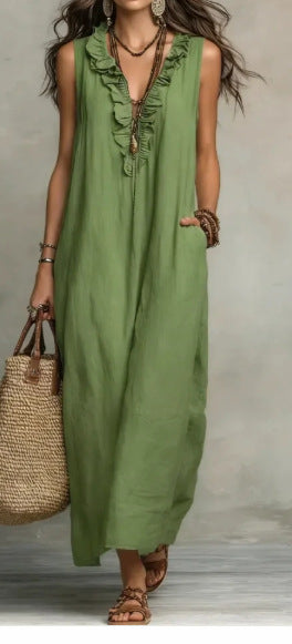Woman wearing a green dress with ruffled details, holding a straw bag against a neutral background.