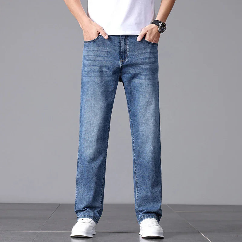 Person wearing blue jeans and a white shirt on a gray background