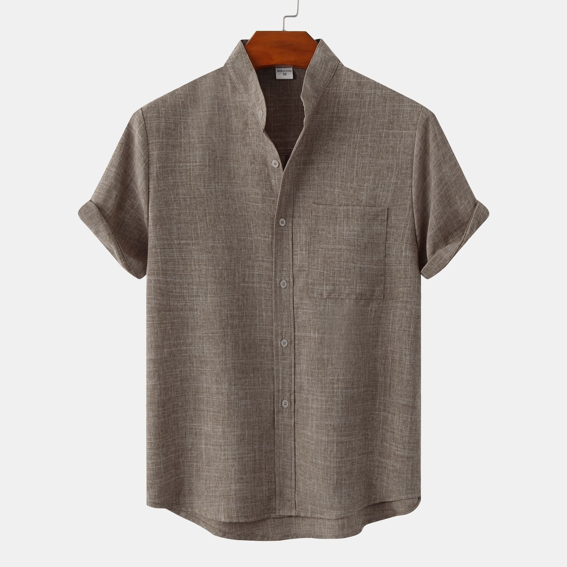 Green short-sleeve shirt on a hanger against a white background