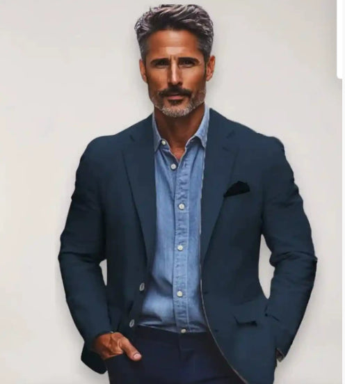 Man wearing a navy blazer over a light blue shirt against a plain background