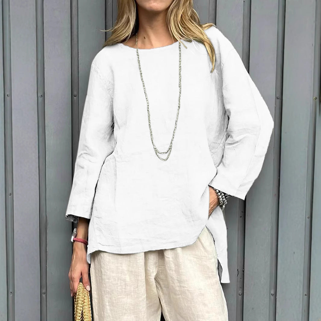 Woman wearing a white top and beige pants against a gray wall