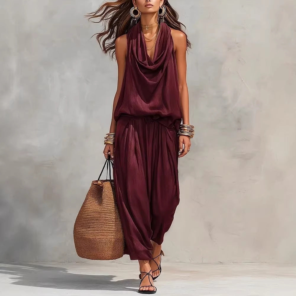 Woman wearing a burgundy dress holding a woven bag against a neutral background