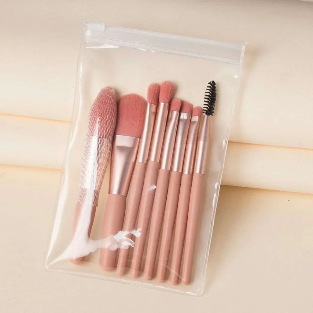 Pink makeup brush set with spoolie in clear pouch on cream background